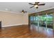 Spacious loft with hardwood floors, ceiling fans, and sliding glass doors to the balcony at 2630 Grand Lakeside Dr, Palm Harbor, FL 34684