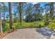 Brick patio with landscaped yard in a verdant, scenic backyard at 2630 Grand Lakeside Dr, Palm Harbor, FL 34684