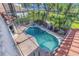 Screened-in pool and spa featuring a brick patio, with views of lush landscaping and the main house at 2630 Grand Lakeside Dr, Palm Harbor, FL 34684