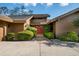 Inviting front entrance with a red double door, mature plants, and stone walkway at 29844 Baywood Ln, Wesley Chapel, FL 33543