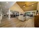 Open-concept living room with wood floors, vaulted ceilings, and access to dining area and kitchen at 29844 Baywood Ln, Wesley Chapel, FL 33543