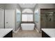 Spa bathroom featuring a standalone tub, glass block windows, and tiled floors at 2997 Eagle Estates E Cir, Clearwater, FL 33761