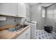 Laundry room with sink, countertop, cabinets, tile flooring, and a modern washing machine at 2997 Eagle Estates E Cir, Clearwater, FL 33761