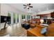 Open-concept living room boasts a leather sectional sofa, hardwood floors, and adjacent modern kitchen at 2997 Eagle Estates E Cir, Clearwater, FL 33761