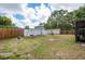 Spacious backyard with a swing set, slide, shed, white fence, and some patio furniture at 333 Acropolis Dr, Dunedin, FL 34698