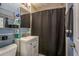 Compact bathroom with blue walls, a white vanity, and a black shower curtain at 333 Acropolis Dr, Dunedin, FL 34698