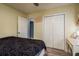 Bedroom with light yellow walls, ceiling fan, closet, wood floors, and queen sized bed at 333 Acropolis Dr, Dunedin, FL 34698