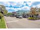 View of a bustling commercial street with shops and parked cars on a sunny day at 333 Acropolis Dr, Dunedin, FL 34698