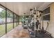 Screened in sunroom featuring multiple pieces of weight lifting equipment and other furniture at 333 Acropolis Dr, Dunedin, FL 34698