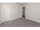 Bedroom with gray carpet and white walls. Doorway leads to another room at 3926 Southern Valley Loop, Brooksville, FL 34601