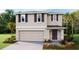 Charming two-story home featuring a 2-car garage and a welcoming covered entrance at 4439 Sand Dollar Way, Zephyrhills, FL 33541