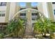 Condominium entrance featuring stairs flanked by tropical plants with an arch overhead at 4681 1St Ne St # 306, St Petersburg, FL 33703