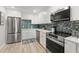 Well-equipped kitchen with stainless steel appliances, white cabinets and a mosaic backsplash at 4681 1St Ne St # 306, St Petersburg, FL 33703