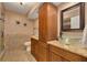 Bathroom with dual vessel sinks, granite countertop, and wooden cabinets at 50 St Andrews Pl # 50, Oldsmar, FL 34677