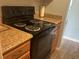 View of the kitchen with a black electric range and wood cabinets at 501 East Bay Dr. # 2003, Largo, FL 33770