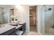 Modern bathroom with double vanity, walk-in shower, and a view into the walk-in closet at 5128 Slate Hue Pl, Apollo Beach, FL 33572