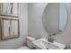 Powder room features a contemporary sink, oval mirror, and decorative wall art at 5128 Slate Hue Pl, Apollo Beach, FL 33572