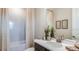 Bright bathroom featuring a combination bathtub and shower with neutral tile and decor at 5128 Slate Hue Pl, Apollo Beach, FL 33572