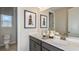 Well-lit bathroom with double sinks, modern fixtures, and decorative wall art at 5128 Slate Hue Pl, Apollo Beach, FL 33572