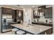 Modern kitchen featuring dark cabinets, stainless steel appliances, a spacious island, and elegant pendant lighting at 5128 Slate Hue Pl, Apollo Beach, FL 33572