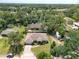 Aerial view of a single-story home with a large backyard surrounded by lush greenery and mature trees at 513 Tweed Ave, Seffner, FL 33584