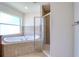 Bathroom view showing bathtub with tile surround and glass-enclosed shower at 513 Tweed Ave, Seffner, FL 33584