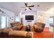 Bright living room with hardwood floors, ceiling fan, comfortable sofas, and a wall-mounted TV at 513 Tweed Ave, Seffner, FL 33584