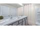Bright bathroom featuring a double sink vanity with gray cabinets, granite countertop, and a shower with a white curtain at 5231 Salt Marsh Rd, Wimauma, FL 33598