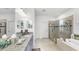Bathroom showcasing a modern double vanity, soaking tub and frameless shower with tiled walls at 5239 Admiral Pointe Dr, Apollo Beach, FL 33572