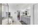 Modern bathroom with a walk-in shower, soaking tub, dual granite vanity, and access to the bedroom at 5239 Admiral Pointe Dr, Apollo Beach, FL 33572