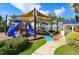 Fun-filled community playground with slides, climbing structures, and a gazebo, set amidst lush landscaping at 5239 Admiral Pointe Dr, Apollo Beach, FL 33572