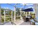 Outdoor dining and lounge area in a screened lanai overlooking the backyard at 5239 Admiral Pointe Dr, Apollo Beach, FL 33572