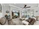 Open living room with large TV, ceiling fan, coastal decor, and access to the lanai at 5239 Admiral Pointe Dr, Apollo Beach, FL 33572