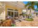 A covered patio with seating, a ceiling fan, stone pillars, tropical landscaping and an inground pool at 556 21St Ne Ave, St Petersburg, FL 33704