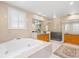 Luxurious bathroom featuring a soaking tub, walk-in glass shower, and window with plantation shutters at 556 21St Ne Ave, St Petersburg, FL 33704