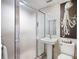 Compact bathroom with frosted glass shower door, pedestal sink, and tiled walls, offering a clean and functional space at 556 21St Ne Ave, St Petersburg, FL 33704