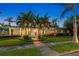 Charming two-story home with a large front porch, lush landscaping, and mature palm trees at 556 21St Ne Ave, St Petersburg, FL 33704