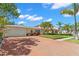 Charming yellow two-story home featuring an attached garage, a brick driveway, and lush landscaping at 556 21St Ne Ave, St Petersburg, FL 33704