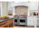 Gourmet kitchen featuring a professional Wolf range, custom hood, and elegant white cabinetry for a chef-inspired space at 556 21St Ne Ave, St Petersburg, FL 33704