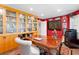 Bright red office with hardwood floors, a large wooden desk, built in bookshelves, and exterior window at 556 21St Ne Ave, St Petersburg, FL 33704