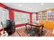 Home office featuring bright red walls, built-in bookshelves, and a large desk with decorative rug at 556 21St Ne Ave, St Petersburg, FL 33704