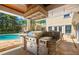 Outdoor kitchen with stainless steel appliances, stone accents, and convenient access to the pool and backyard at 556 21St Ne Ave, St Petersburg, FL 33704