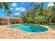 A backyard featuring a pool, spa, putting green, and outdoor kitchen with bar seating under a covered patio at 556 21St Ne Ave, St Petersburg, FL 33704