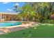 A backyard pool and spa with a putting green, and an outdoor kitchen and lounge area at 556 21St Ne Ave, St Petersburg, FL 33704