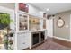 Elegant wet bar with custom cabinets, a wine refrigerator, and decorative shelving for a perfect entertaining space at 556 21St Ne Ave, St Petersburg, FL 33704