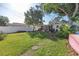 Spacious backyard showing a well-maintained lawn, mature trees, stepping stones, and a white vinyl fence at 633 47Th N Ave, St Petersburg, FL 33703