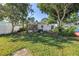 Expansive backyard featuring lush lawn, mature trees, a storage shed, and a cozy screened porch at 633 47Th N Ave, St Petersburg, FL 33703
