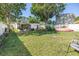 A fenced backyard with lush green grass, a shed, and mature trees at 633 47Th N Ave, St Petersburg, FL 33703
