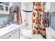 Bright bathroom featuring a white vanity, colorful shower curtain, and tub-shower combination at 633 47Th N Ave, St Petersburg, FL 33703