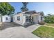 Side view of the house with a detached storage shed, a seating area, and tidy landscaping at 633 47Th N Ave, St Petersburg, FL 33703